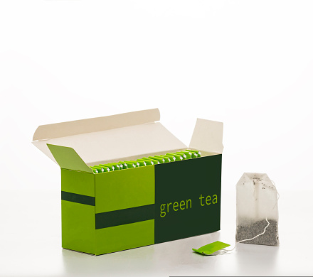 Box with green tea bags isolated on white