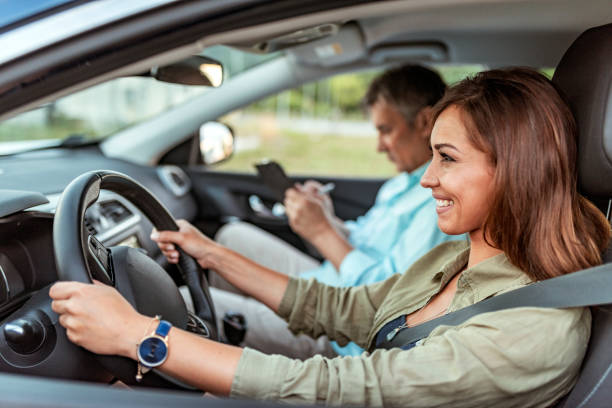 test di guida, concentrato sulla strada davanti a lei - car insurance women driving foto e immagini stock
