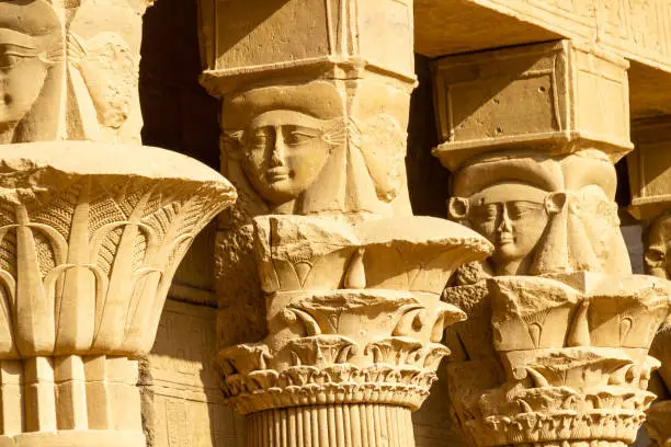 Beautifull column decoration of heads in the courtyard of the temple of Philae
