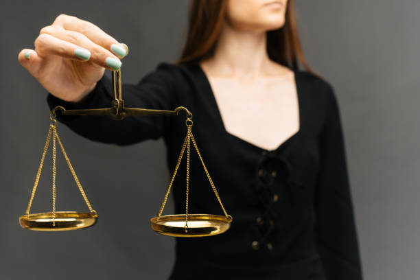 istock Serious woman holding the justice scale on dark background 1160363250