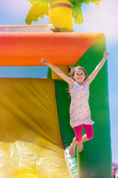 beautiful girl playing in an inflatable playground - inflatable child playground leisure games imagens e fotografias de stock