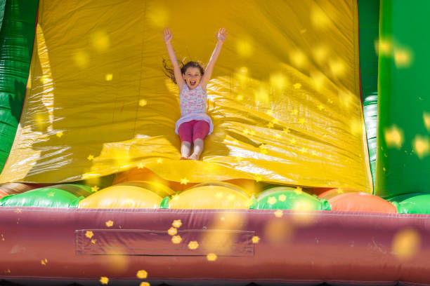 beautiful girl playing in an inflatable playground - inflatable child playground leisure games imagens e fotografias de stock