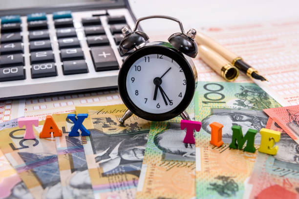 istock Australian dollars, clock and calculator on tax form 1160365928