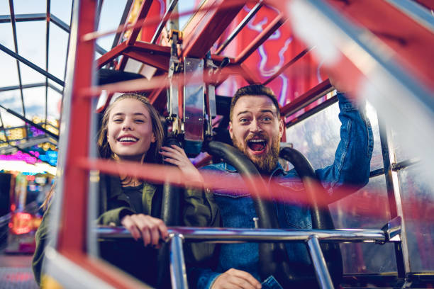 カップルは、遊園地で怖い乗り物をしようとしています - rollercoaster carnival amusement park ride screaming ストックフォトと画像