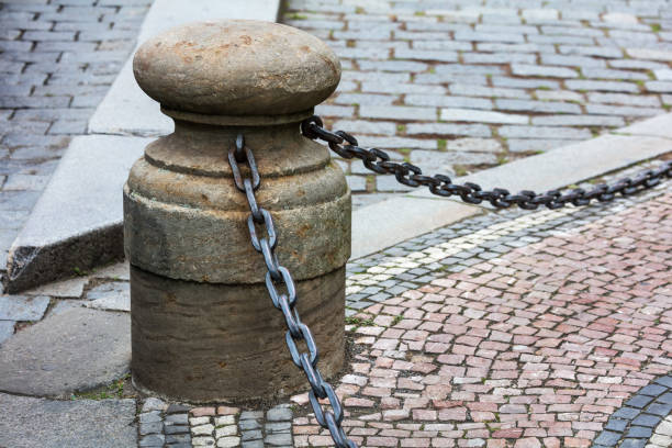 fencing of sidewalk in form of posts with iron chains