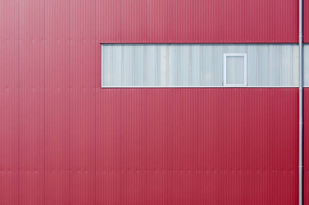 istock Modern factory facade clad with red elements and a band of light 1160373235