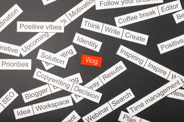 istock Cut paper inscription vlog on a red background, surrounded by other inscriptions on a dark background. Word cloud concept. 1160374331