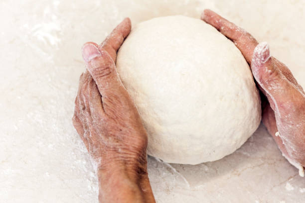istock Female hands kneading making dough for dumplings on the table on kitchen 1160374673