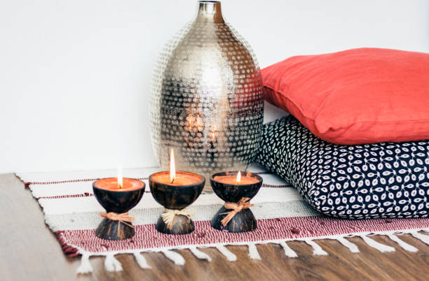 istock Cozy home interior decor, burning candles in coconut shell on a multi-colored rug 1160376487