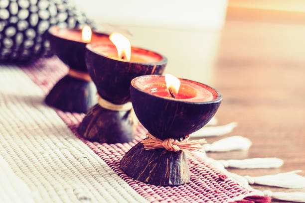 istock Cozy home interior decor, burning candles in coconut shell on a multi-colored rug 1160376512