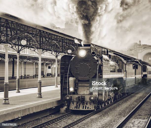 Retro Train Departs From Railway Station Building Stock Photo - Download Image Now - Train - Vehicle, Old, 19th Century