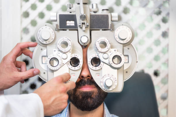 istock Optometrist doing sight testing for male patient In clinic. Male ophthalmologist examining patient man with optometrist trial frame. 1160378714