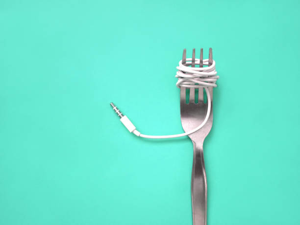 istock A fork with music jack plug in color background. 1160382370