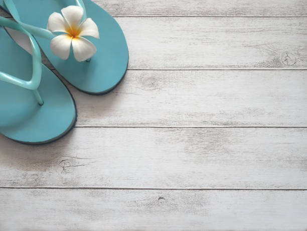 istock Beach slippers on wooden background. 1160382404