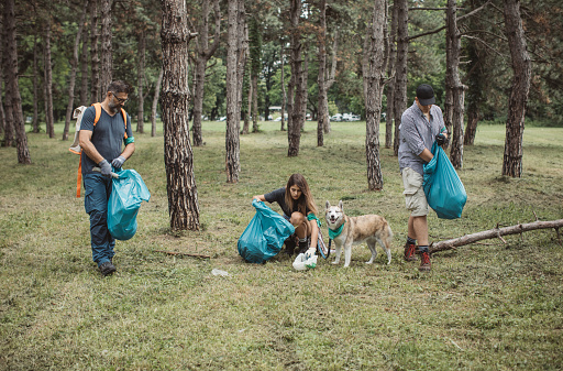 Family collecting garbage from park. Environmental awareness is important to save our planet.