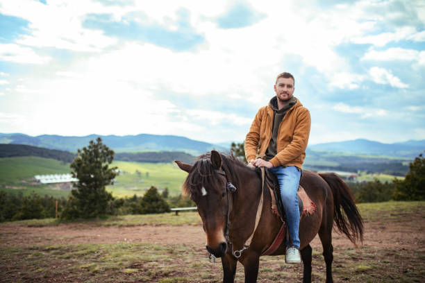 młody człowiek jeździ konno - cowboy horseback riding nature blue zdjęcia i obrazy z banku zdjęć