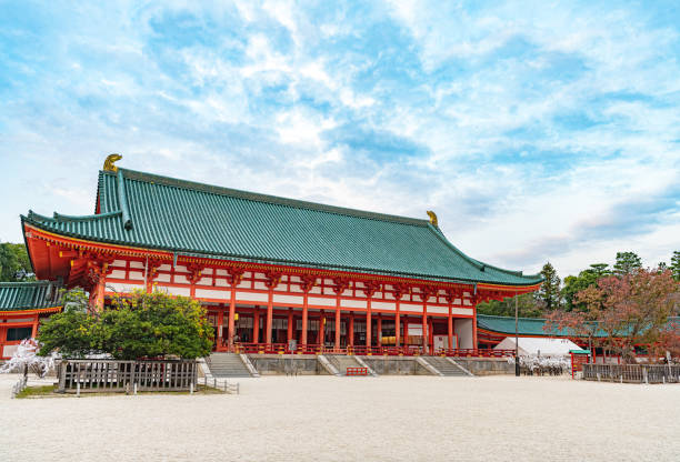 Kyoto, Japan - May 2014: View of the inner courtyard of Heian Shrine with crowd of people walking with main prayer hall, Byakko-rou tower and cloudy sky background.