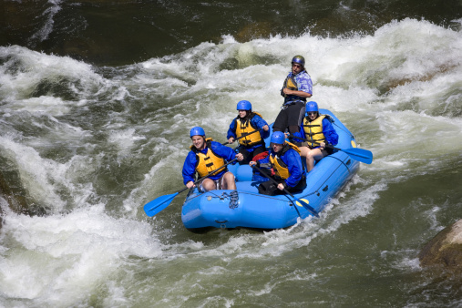 A group of men and women, with a guide,white water rafting on the Arkansas River in Colorado.