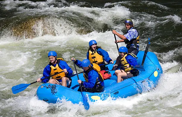 A group of men and women, with a guide, white water rafting on the Arkansas River in Colorado.