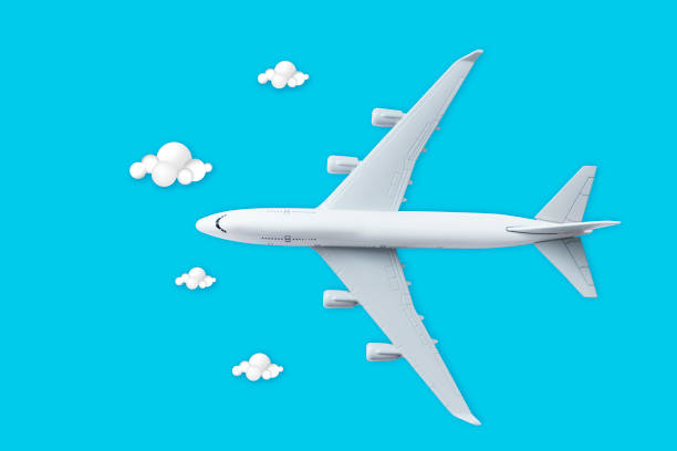 istock High angle view of airplane toy and clouds on blue sky background 1160396872