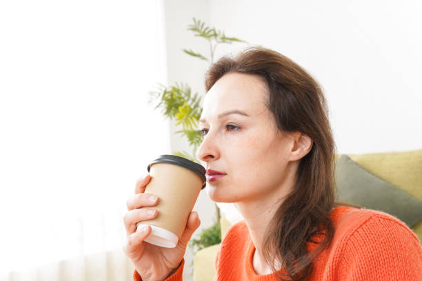 istock Young woman drinking coffee at home 1160399493