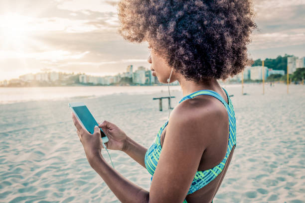 istock young woman using her smartphone after exercising 1160400734