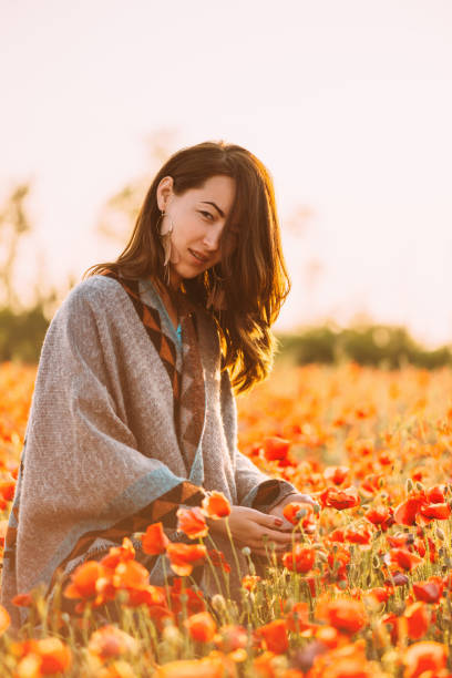 istock Woman walking in poppies meadow in spring. 1160401865