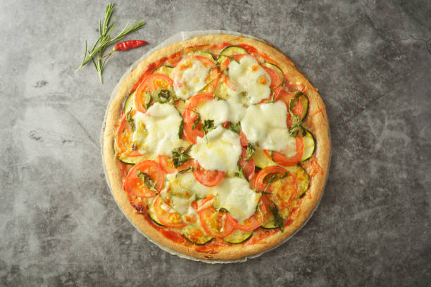 pizza vegetariana a base di pasta integrale, con zuchinni, pomodori e mozarella. pizza sana e dietica. vista dall'alto. - mozarella sul tavolo foto e immagini stock