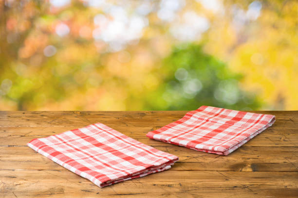istock Empty wooden table with tablecloth over autumn nature park background 1160405034