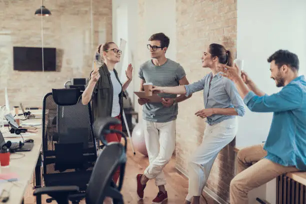 Photo of Group of employees are enjoying coffee break in workroom