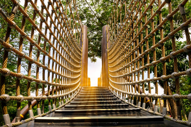wooden bridge with strong robe at playground perspective