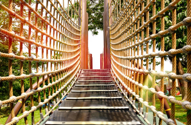 istock wooden bridge with strong robe at playground perspective 1160410158