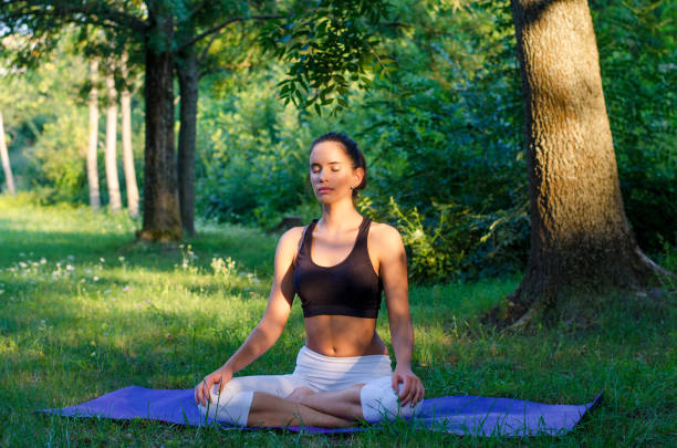 istock Woman meditates in the summer forest 1160410751