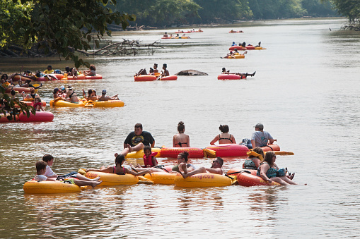 Duluth, GA / USA - July 14, 2018:  Several groups of people float down the Chattahoochee River on rafts and innertubes at the Whatever Floats Your Boat event on July 14, 2018 in Duluth, GA.