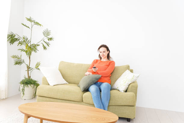 istock Young woman watching TV at home 1160413348