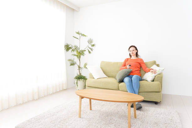 istock Young woman watching TV at home 1160413352