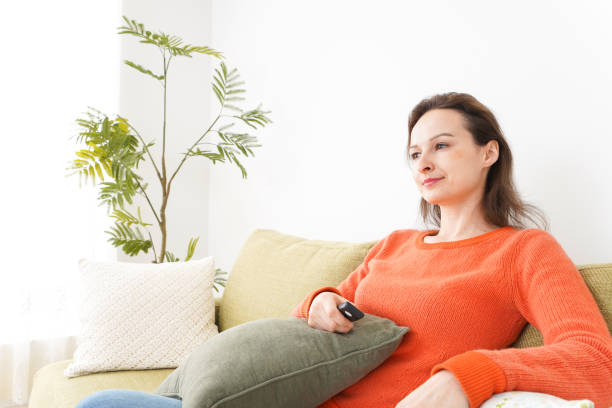 istock Young woman watching TV at home 1160413376
