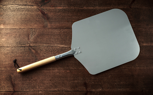 pizza peel paddle italian style with wood handle on wooden table