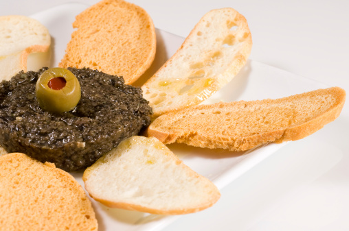 Olive tapenade appetizer on white background
