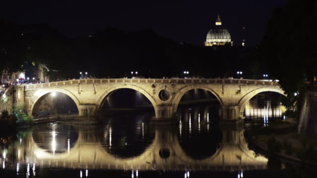 Illuminated ancient Roman bridge over the tiber river at night