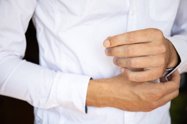 istock man fastens buttons on sleeves white shirt 1160419733