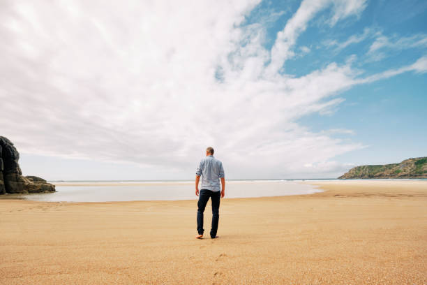 istock man walking alone on an empty beach, time out, getting away from it all, solitude. Pedn Vounder, Cornwall. 1160420735
