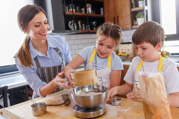 istock Mother Teaching Kids to Cook and Help in the Kitchen. Baking with children. 1160422331