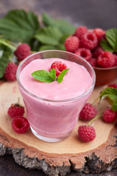 Raspberry smoothie in glass jar. Healthy homemade beverage and fresh raspberries.