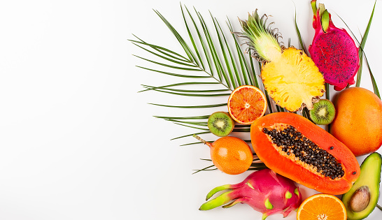 Still life with fresh assorted exotic fruits on a palm leaf. Concept of healthy eating with fruits. Top view.