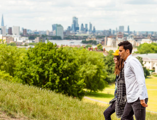 Couple walking in Greenwich Park, London A couple in London's Greenwich Park. greenwich london stock pictures, royalty-free photos & images