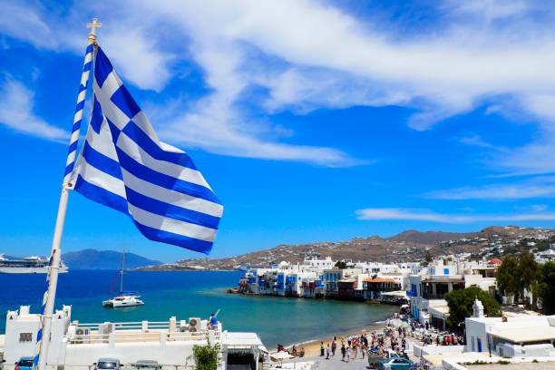 view of the port of mykonos and the greek flag from the white windmills in the cyclades in the heart of the aegean sea - recreational boat small nautical vessel sea imagens e fotografias de stock