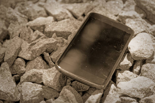 istock Broken cellphone abandoned and lost among the gravel 1160426209