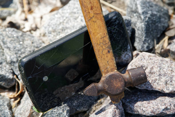 istock Smartphone broken glass with hammer on gravel stones. Selective focus 1160426223