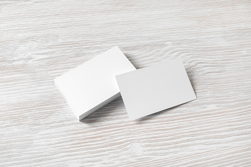 Blank business cards on light wooden background. Mockup for branding identity.